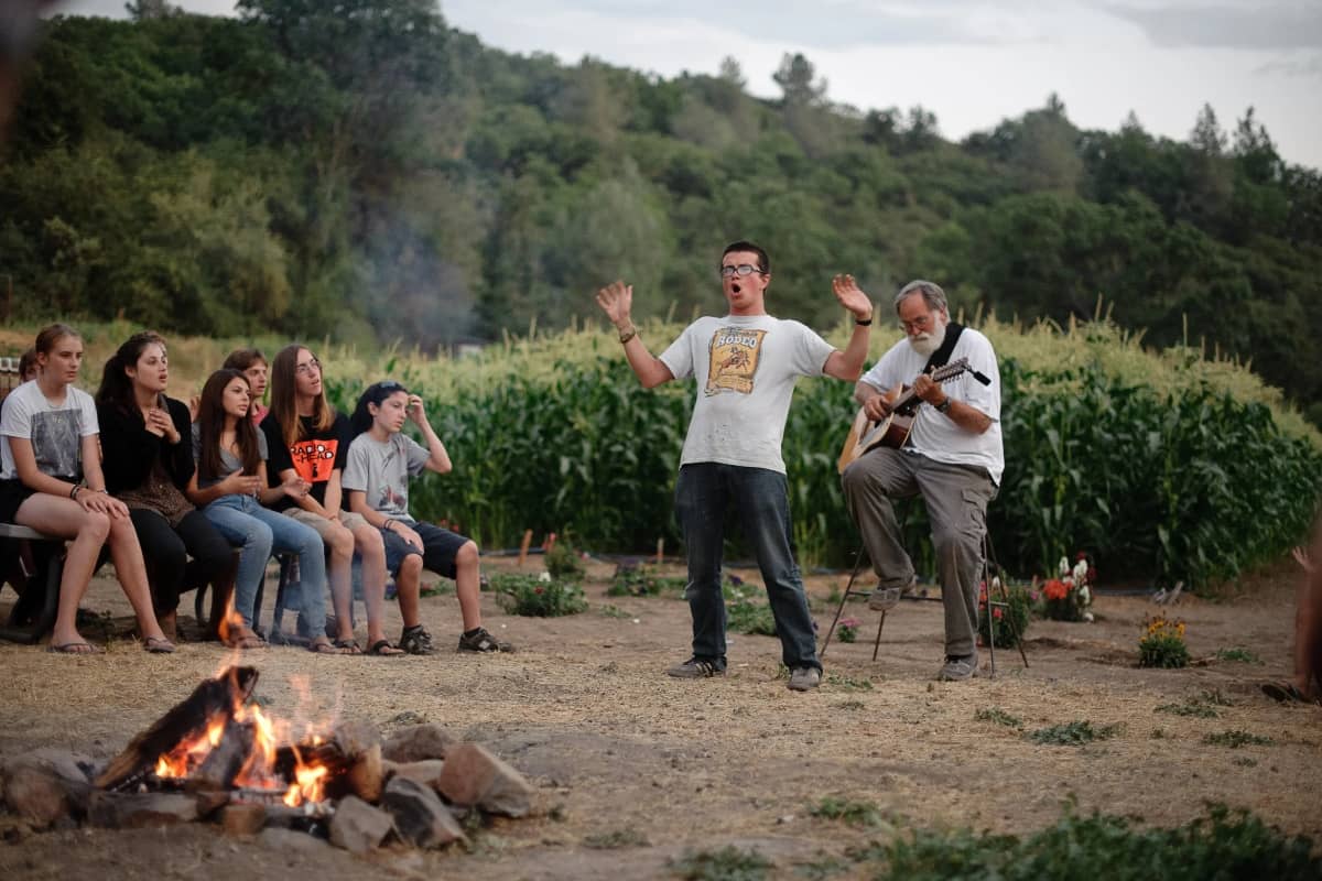 Boy singing infront of the campfire